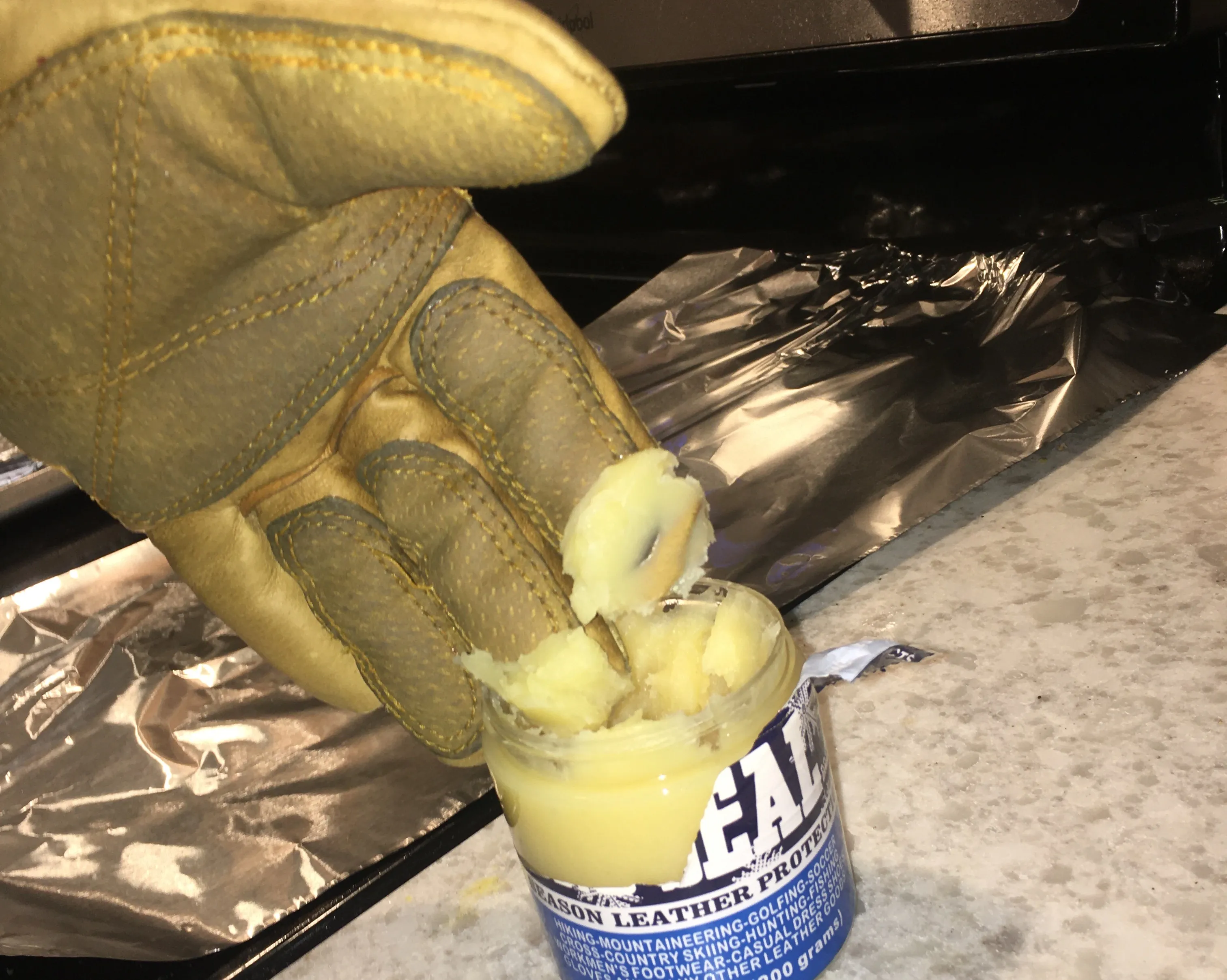 Dipping gloves into Sno-Seal